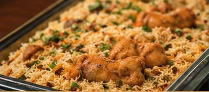 Tray of chicken biriyani with coriander, ready to serve